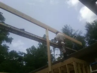 Carpenter setting a ridge beam over a new addition frame — Ice Dam Removal by Roofing Brothers in Big Bear City