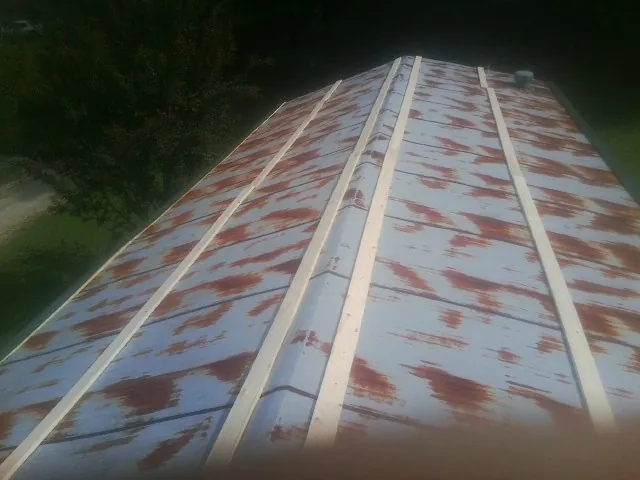 Rusted metal roof panels with new wood purlins before replacement — Storm Damage Roof Repair in Big Bear City by Roofing Brothers