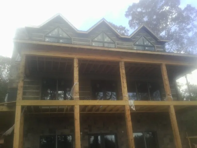 Dormers and porch framing on a large log home under construction — Roof Coating work by our crew in Big Bear City