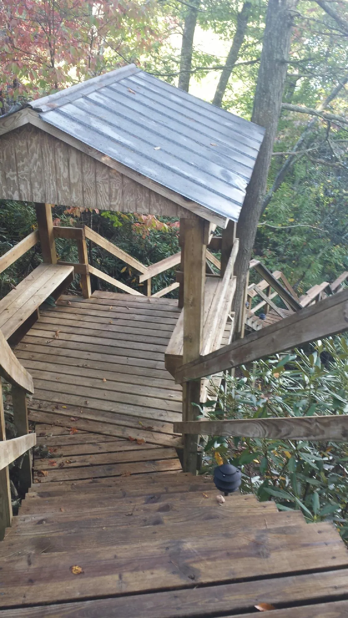 Metal roofed shelter over wooden steps on a wooded walkway — Skylight Repair & Installation work by our crew in Big Bear City